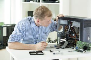 Image of man fixing computer at home